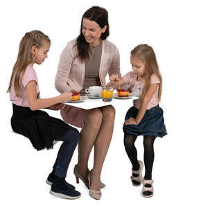 mother with two kids eating cake at a cafe