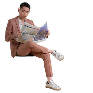 asian man in a pink suit sitting and reading a newspaper