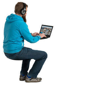 man with headphones sitting at the desk and working