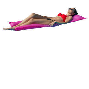 woman sunbathing on a swim mattress in the pool