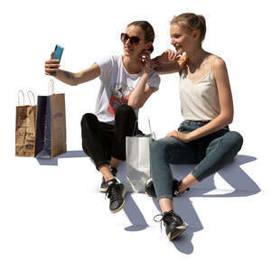 two young women sitting on stairs and taking a selfie