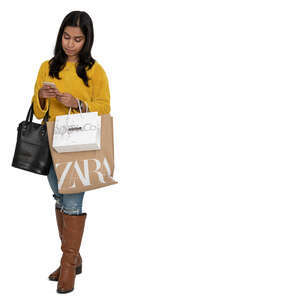cut out indian woman with shopping bags standing and looking at her phone