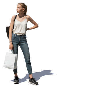 young woman with a shopping bag standing outside in the sun