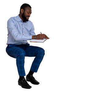 cut out man sitting at a desk and writing notes