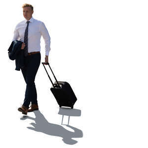 cut out backlit businessman walking and pulling a suitcase