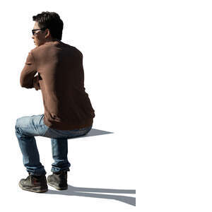 cut out backlit man sitting and leaning on a  table