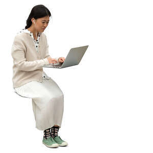 cut out asian woman sitting at a table and working with laptop
