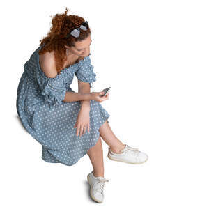 cut out woman in blue dotted dress sitting seen from above