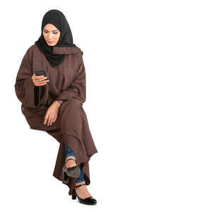 cut out muslim woman in a brown abaya sitting