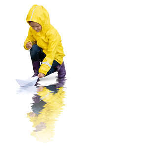 cut out little girl in a yellow raincoat floating a paper boat