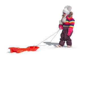 cut out little girl pulling a sledge in the snow
