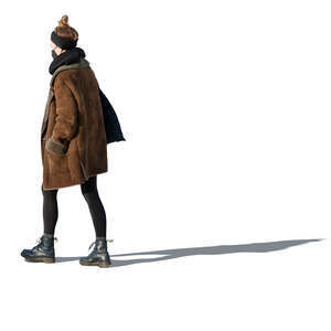 cut out woman in a brown overcoat and wearing a face mask walking