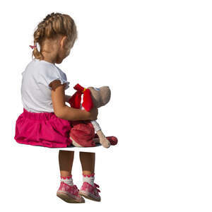 little girl with her toy sitting on a chair
