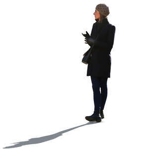 backlit woman in a black autumn jacket standing
