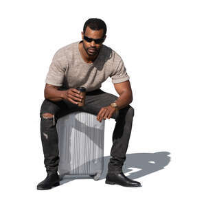 cut out man sitting on a suitcase and drinking beer