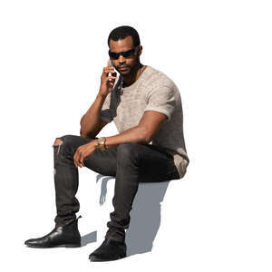 cut out black man sitting and talking on a phone