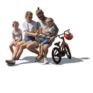 cut out family with two kids sitting on a bench and drinking juice