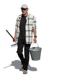 cut out older man walking in the garden carrying a bucket and a rake