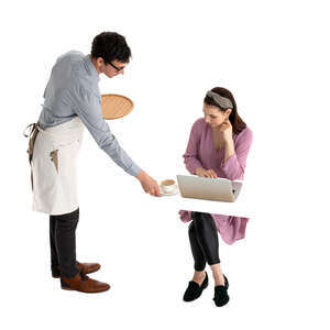 waiter serving coffee to a woman sitting at a table