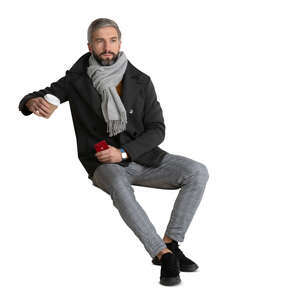 cut out man in an overcoat sitting and drinking coffee