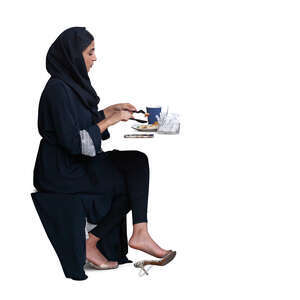 cut out muslim woman sitting in a cafe and eating