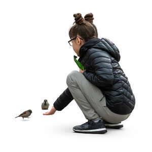 cut out girl squatting and feeding pigeons