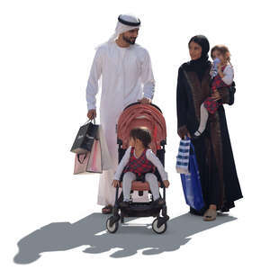 backlit arab family with shopping bags walking
