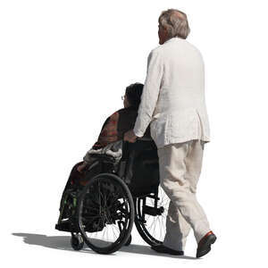 elderly man pushing a woman in a wheelchair