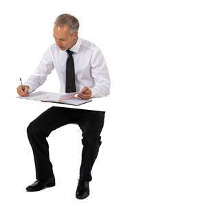 cut out businessman sitting at a table and writing