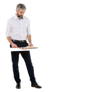 cut out man standing at a table and reading a newspaper