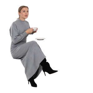 cut out woman in a grey dress drinking coffee in a cafe