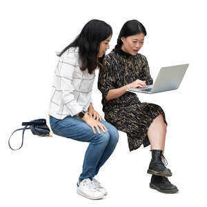 two cut out asian women sitting and looking smth from a computer