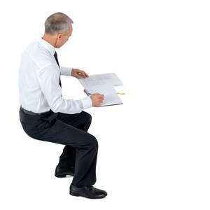 cut out office worker sitting and writing seen from above