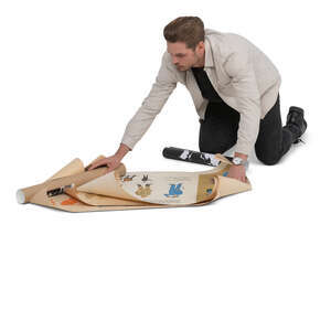 cut out man kneeling on a ground and looking some design papers