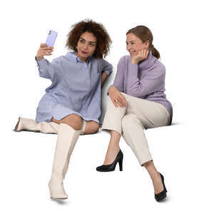 two cut out women sitting and taking a selfie