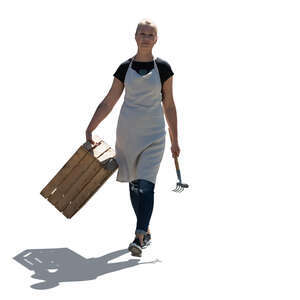 cut out backlit female gardener with a wooden crate walking