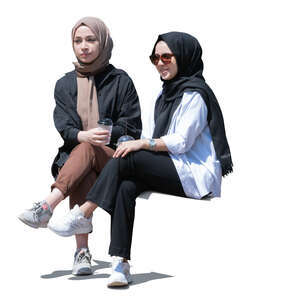 two cut out young muslim girls sitting