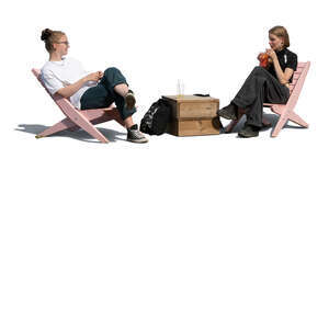 two cut out young women sitting on garden chairs and drinking
