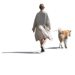 cut out woman in a flowy white jacket walking a dog