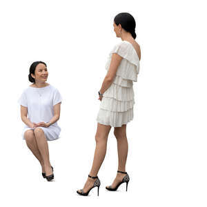 cut out woman sitting and talking to another woman standing next to her