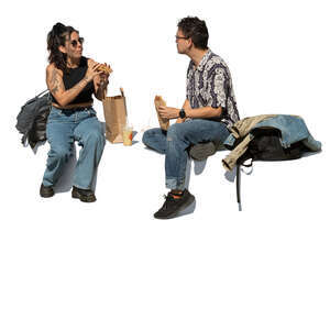 man and woman sitting and eating lunch outside on the street