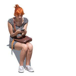 young woman with a phone sitting outside in sunlight
