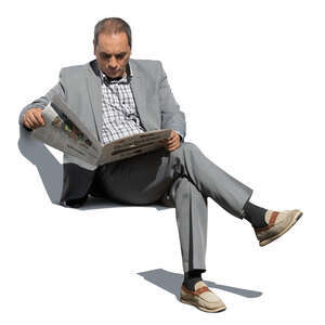older man in a grey suit sitting and reading a newspaper