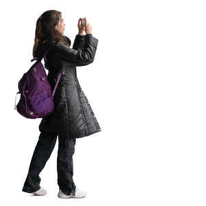 woman with a backpack taking pictures with her phone