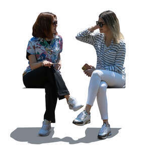two cut out backlit young women sitting and talking