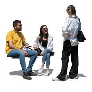 cut out woman standing and talking to her two friends sitting on a bench