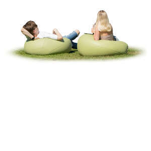 man and woman lying on the bean chairs outside on the grass
