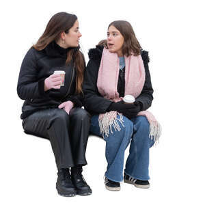 two women in winter sitting and drinking hot coffee