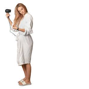 woman in a bathrobe standing and drying her hair