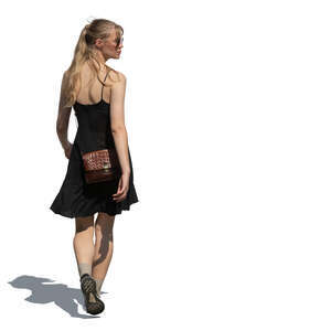 woman in a black summer dress walking and looking back over her shoulder